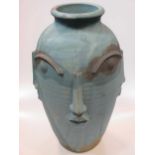 A modern ceramic vase with moulded facial features 48cm high