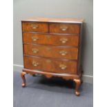 A George III walnut bow front chest of two short over three graduating long drawers on later pad