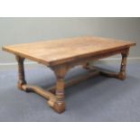 A 17th century style oak dining table, with plank top and draw-leaf ends, on ring turned baluster