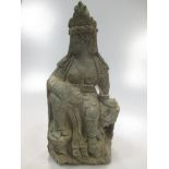A Chinese carved green stone figure of Gyanyin, in Tang style, seated on a rocky dias, 28cm high