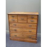 An Edwardian stained wood chest of drawers with reeded horizontal fascias and brass bail handles 120