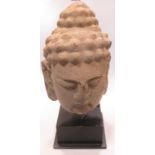 A cast concrete and painted head of Buddha, 34cm high