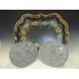 A floral decorated tin tray in Victorian style, and a pair of grey painted plaster wall plaques with