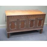 A late 17th century oak panelled coffer with carved decoration, on stile legs, 86 x 140 x 64cm wide