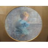An early 20th century oil study of a young child writing, circular, probably on canvas board, 22cm