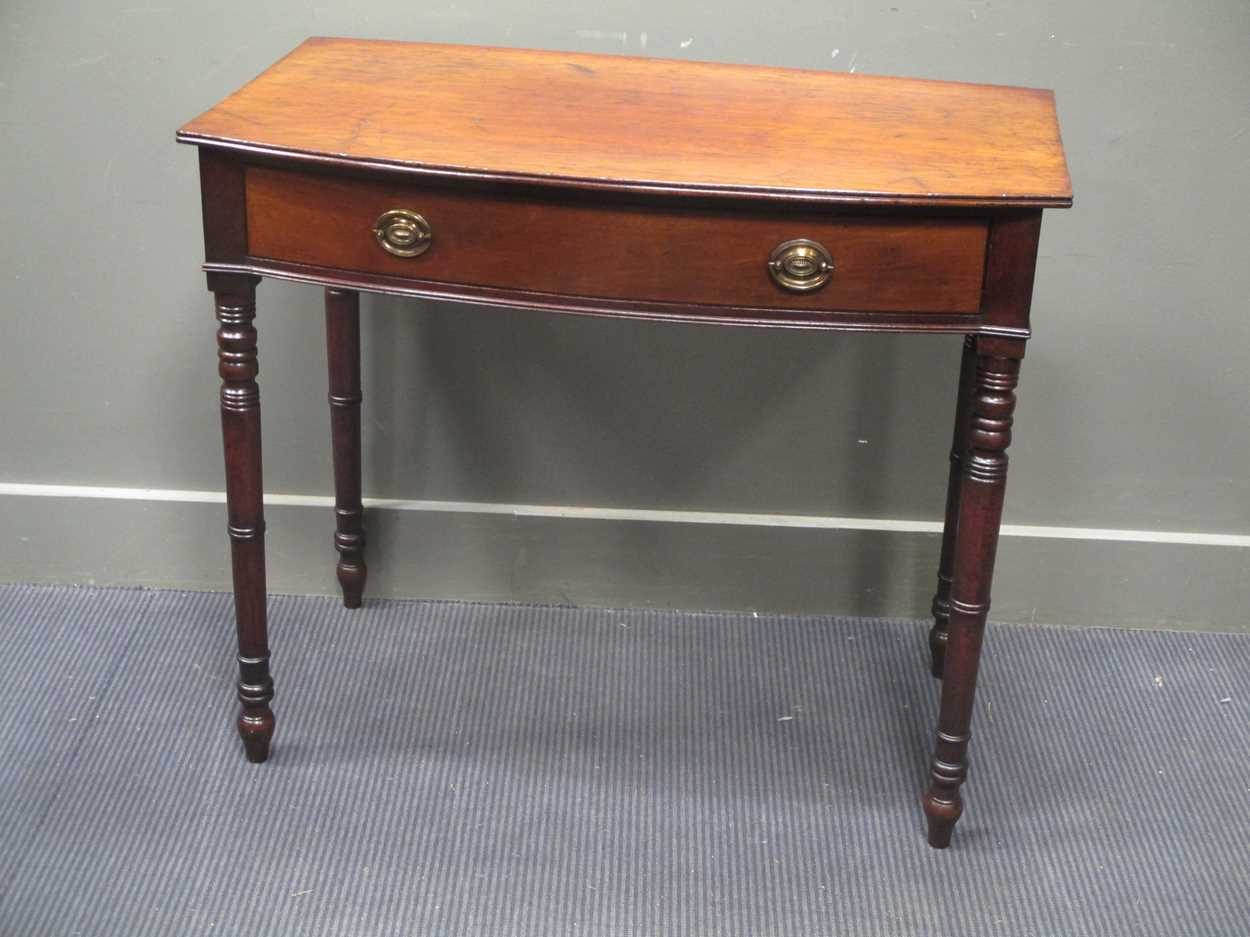 A late George III mahogany bow front side table the single frieze drawer over ring turned tapering