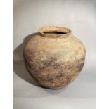 A Chinese grey-ware pottery large compressed jar with grooved decoration throughout, perhaps Warring