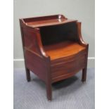 A George III mahogany serpentine front converted shoe cabinet with rising seat on brass castors,