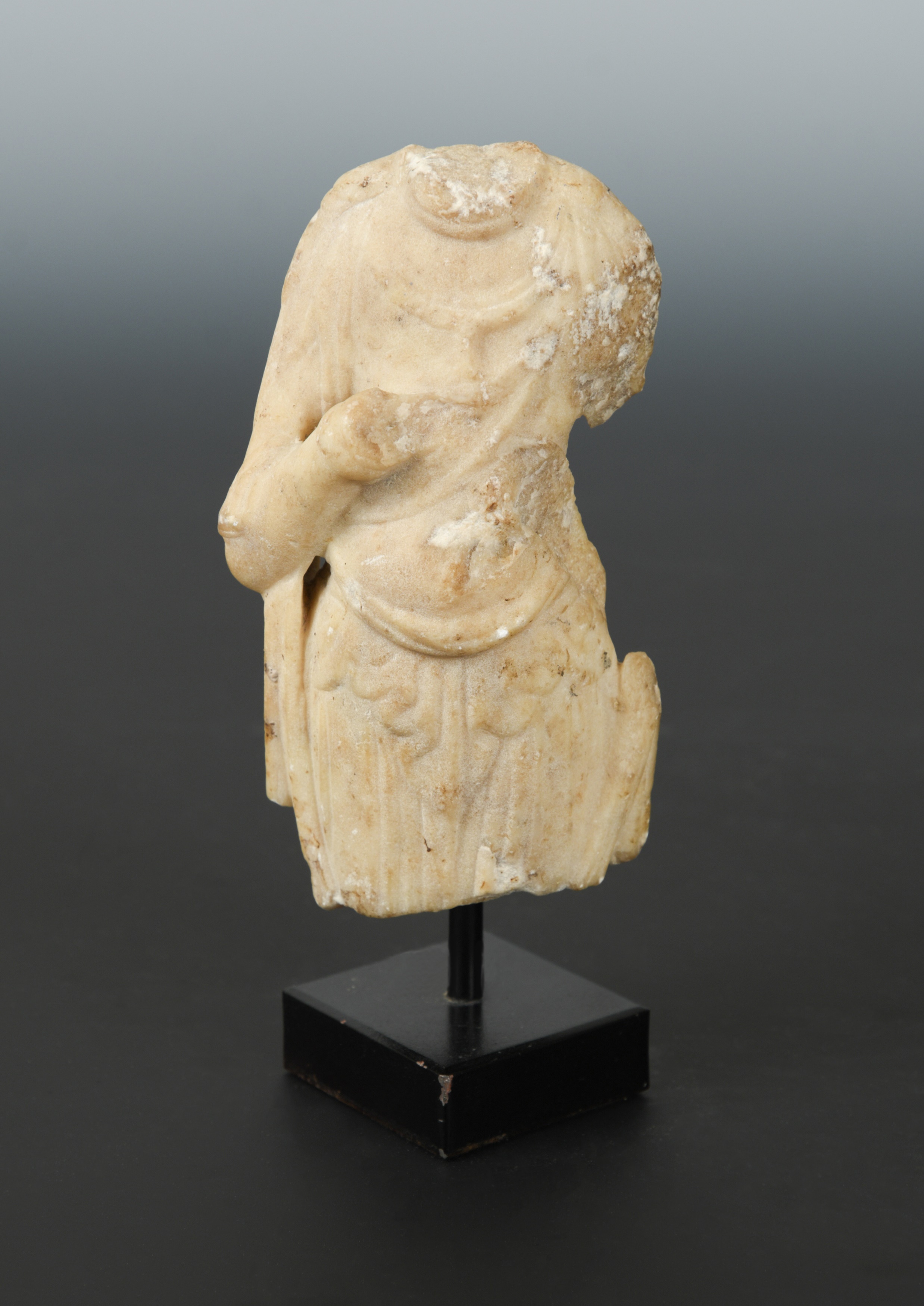 A Chinese white marble fragmentary torso of a Buddhist deity, in Sui Dynasty style, 14cm high