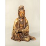 A Chinese carved soapstone figure of Guanyin, seated holding a scroll, Republic Period in Qing
