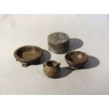 A group of four Chinese green and grey stone small vessels, archaic type, including a five footed