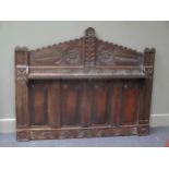 A carved oak panelled head board with triangular arched pediment and shelf 110 x 137cm