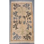 A harlequin pattern rug, 146 x 82cm; two pale ground Chinese rugs, 179 x 85.5cm & 174 x 92cm (3)