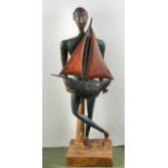A wood and plaster figure of standing ethnic man holding a pond yacht, 109cm tall