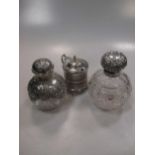 Two silver mounted cut glass scent bottles, one with cupid heads design together with a Victorian