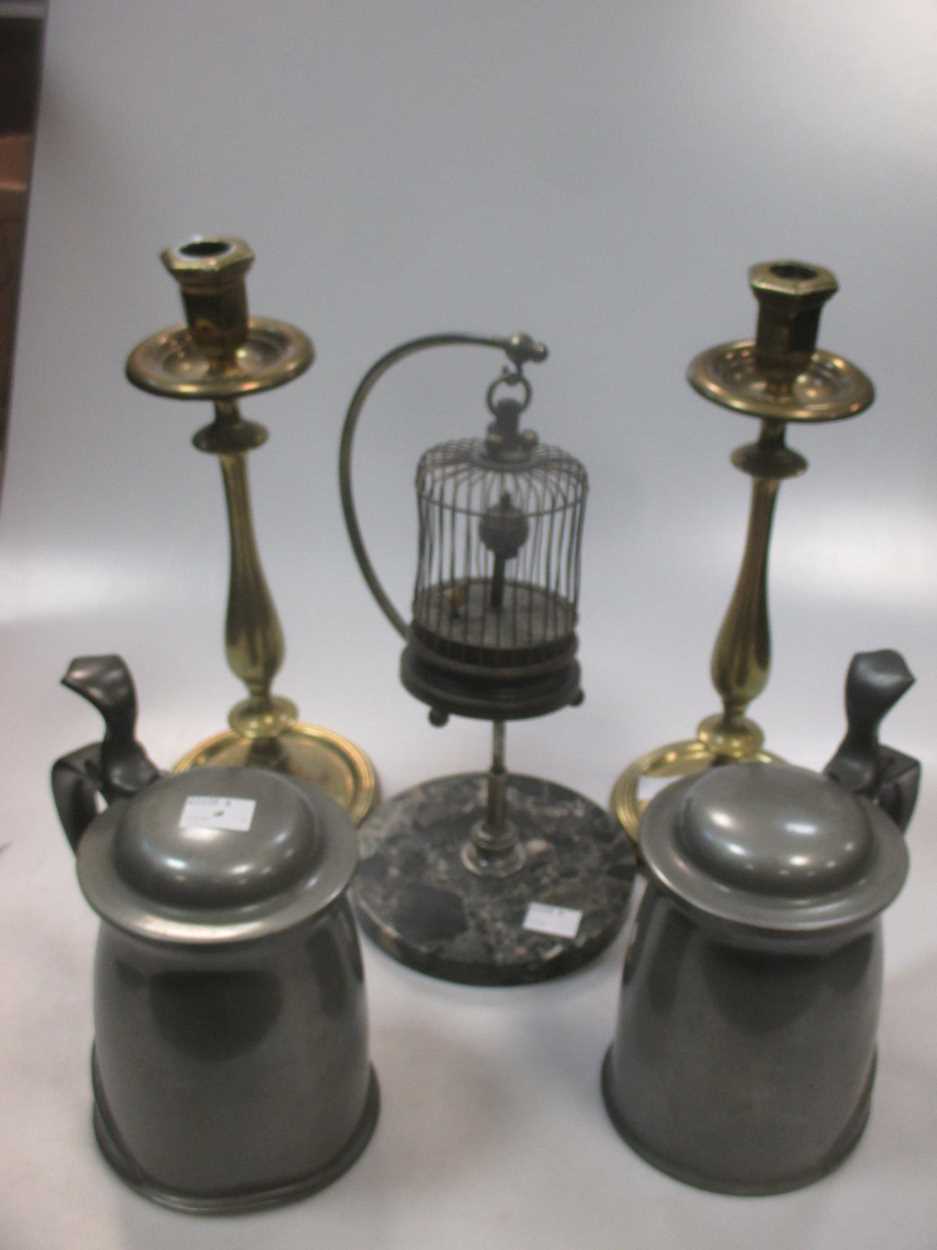 A pair of late 19th century brass candlesticks, a model bird in a suspended cage musical box and a