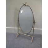 A brass framed oval dressing table mirror, with dove cresting 75cm high 44cm wide