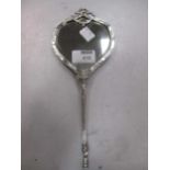 A French silver leather backed hand mirror, with devilish mask decoration