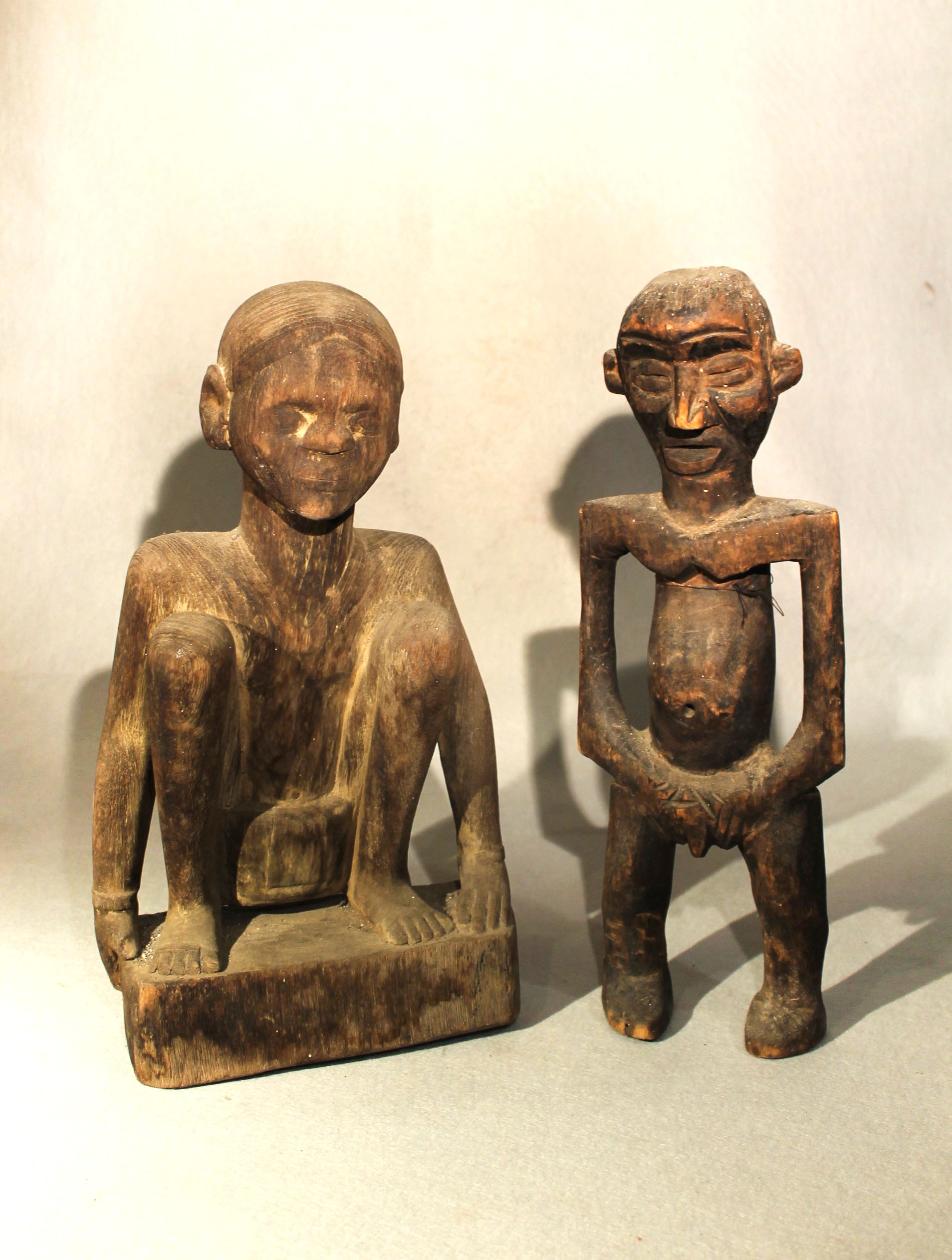 A Naga carved wood squatting figure, and a Cameroon standing figure, both mid 20th century, both