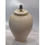 A ribbed cream coloured ceramic lamp base of ovoid form