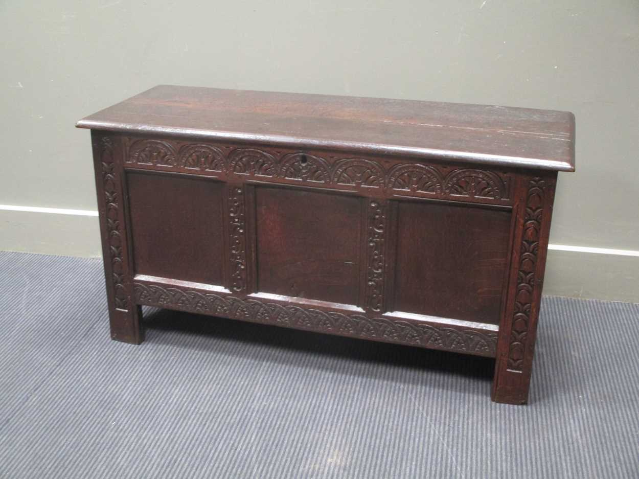 An 18th century three panel coffer with carved front decoration and internal candle box with lid