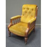 An Edwardian blonde oak armchair with button back upholstery