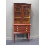 An Edwardian mahogany display cabinet, the upper section with adjustable shelves enclosed by a
