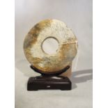 A Chinese chicken bone jade bi disc in Neolithic style, 12.5cm high