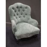 A Victorian green button-backed nursing chair, on ebonised baluster feet with castors