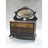 An early 20th century manicure set contained within a miniature mahogany dressing chest,