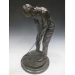 A bronze model of a golfer putting, 42cm