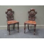 A pair of Victorian mahogany cartouche back hall chairs