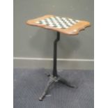 A walnut occasional table, inlaid with tile chequer top with shaped edge on associated cast iron