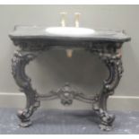 A wash basin set into a serpentine marble surround with metal rococo style stand, 102cm wide