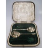 A pair of silver gilt serving spoons - cased