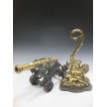 A brass and cast metal canon, 49cm; together with a brass doorstop, with a figure of a lion (2)
