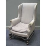 A grey covered wing armchair on shaped legs