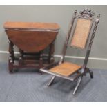 An oak gateleg occasional table together with a carved folding chair having Prince of Wales