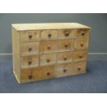 A 20th century pine bank of fourteen drawers with turned knob handles 78 x 117 x 45.5cm