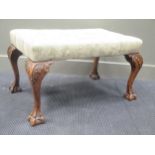 A large George II style stool, the buttoned top on carved claw legs