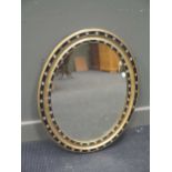 An oval parcel gilt and beaded frame mirror, 73 x 58cm (lacking a few applied beads)