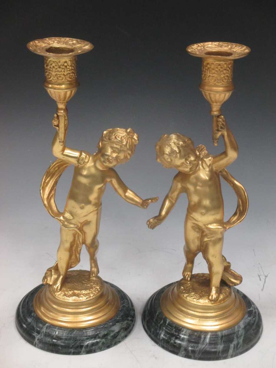 A pair of gilt metal cherub candle sticks, late 20th century, 25cm high