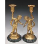 A pair of gilt metal cherub candle sticks, late 20th century, 25cm high