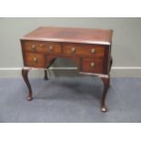 A Georgian style line inlaid mahogany writing desk of four drawers with key on carved shell motif