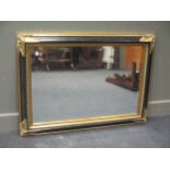 A modern ebonised and gilt wall mirror 78 x 110cm and another in a moulded mottled frame 76 x