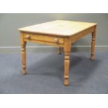 A pine kitchen table, the rectangular top with single end frieze drawer on turned legs 74 x 135 x