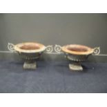 A pair of wrought Iron urns 34cm high and total width 70cm (2)