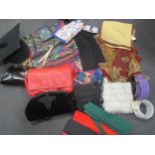 A wicker laundry basket filled with lady's leather handbags, evening bags, leather and silk belts,