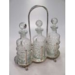 A silver plated three bottle decanter stand, with bottles