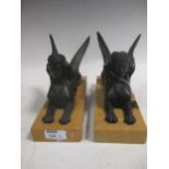A pair of bronzed sphinxes, with marble bases, 24cm wide